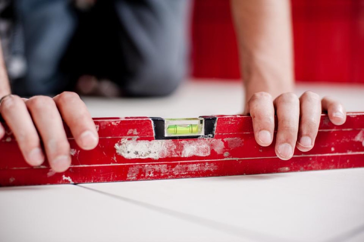 Hands using a spirit level during a home repair