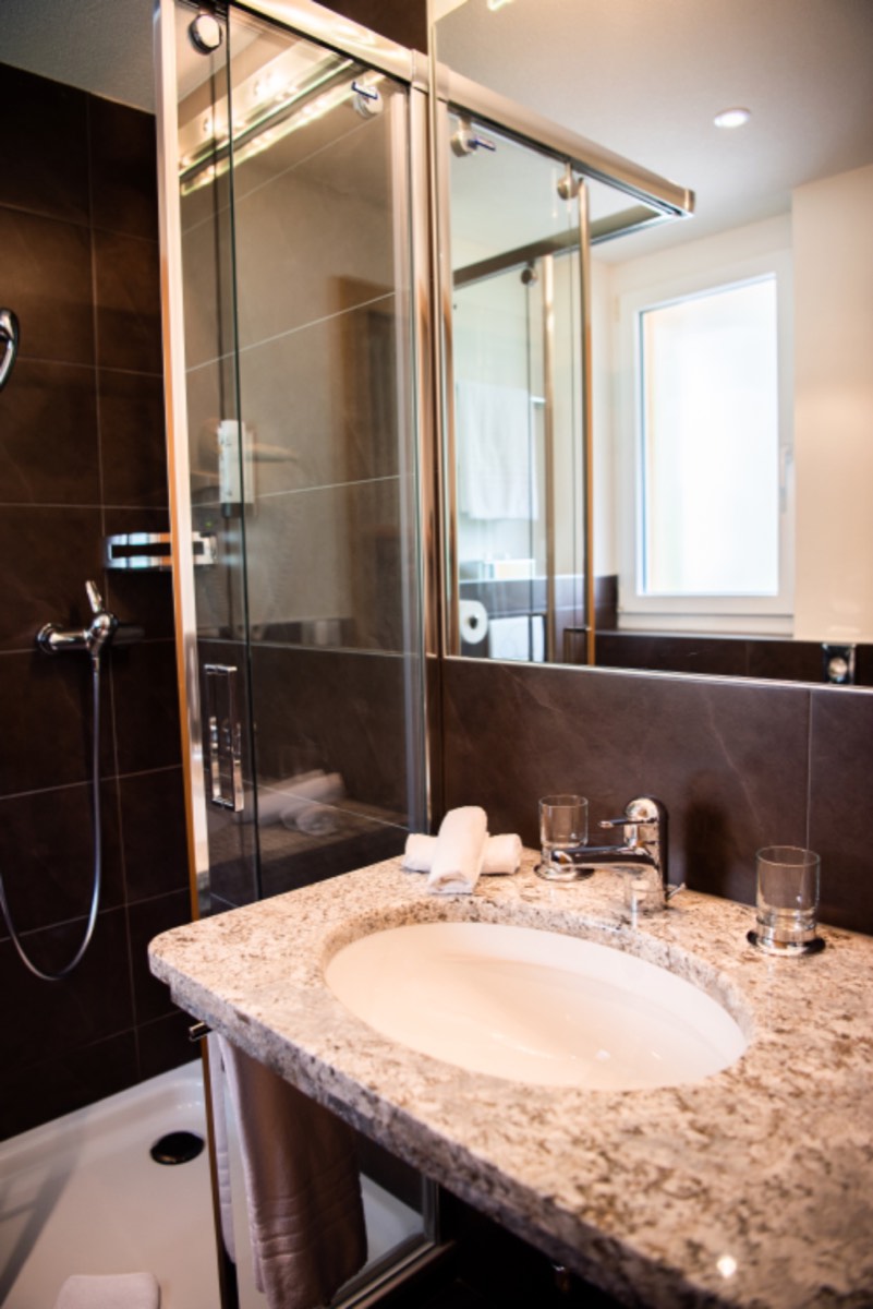 Finished bathroom with a glass shower enclosure and stone vanity